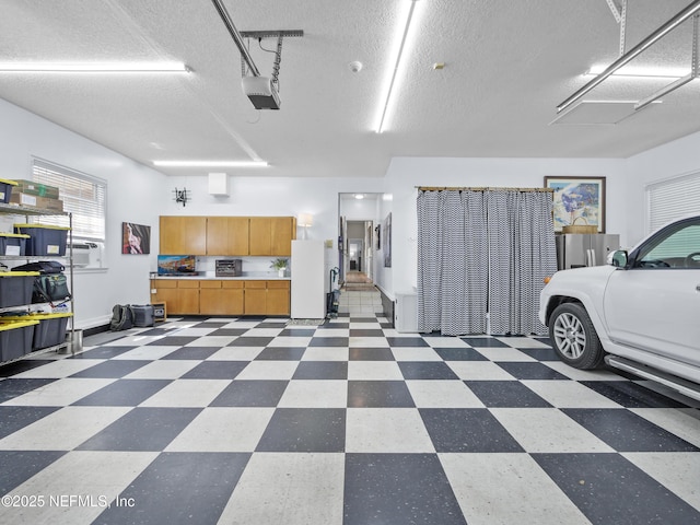 garage featuring a garage door opener and freestanding refrigerator