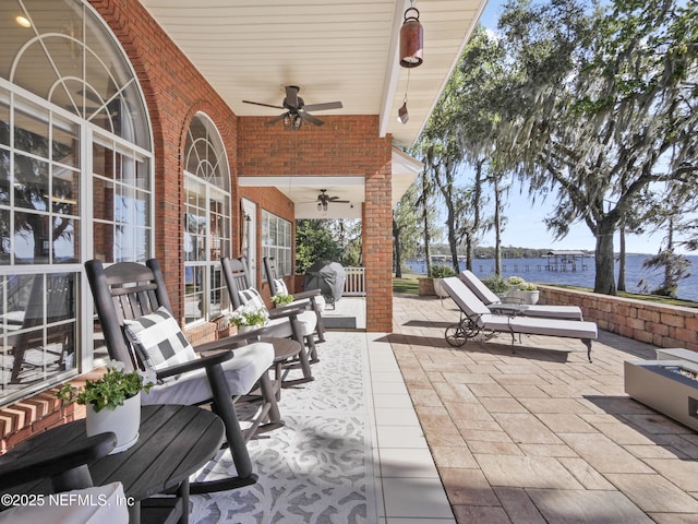 view of patio featuring ceiling fan and a water view