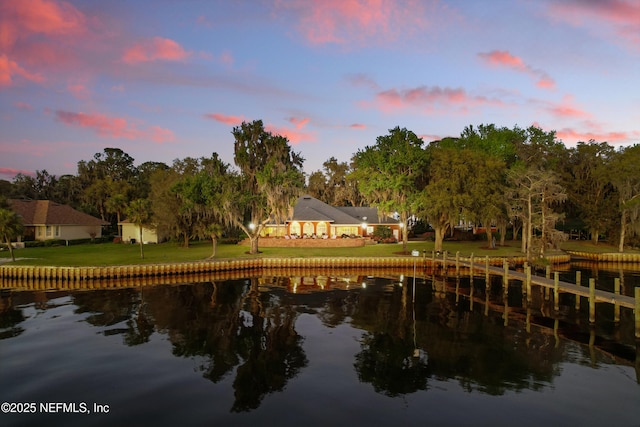 view of dock featuring a lawn and a water view