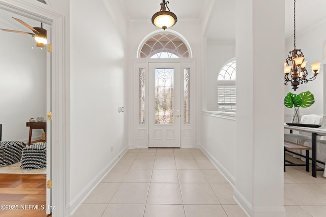 entryway featuring light tile patterned floors, baseboards, and crown molding