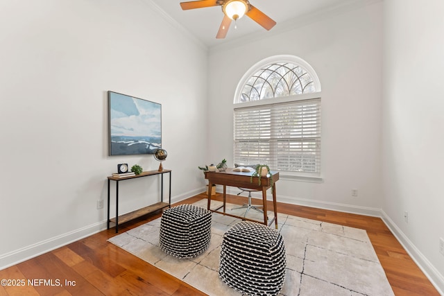 office space with a ceiling fan, crown molding, baseboards, and wood finished floors