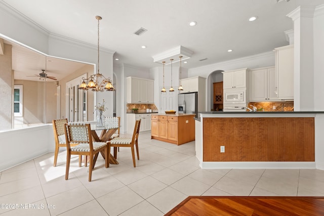 kitchen with light tile patterned floors, white microwave, stainless steel refrigerator with ice dispenser, and visible vents