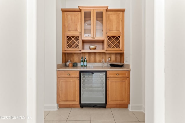 bar featuring light tile patterned floors, wine cooler, and a dry bar