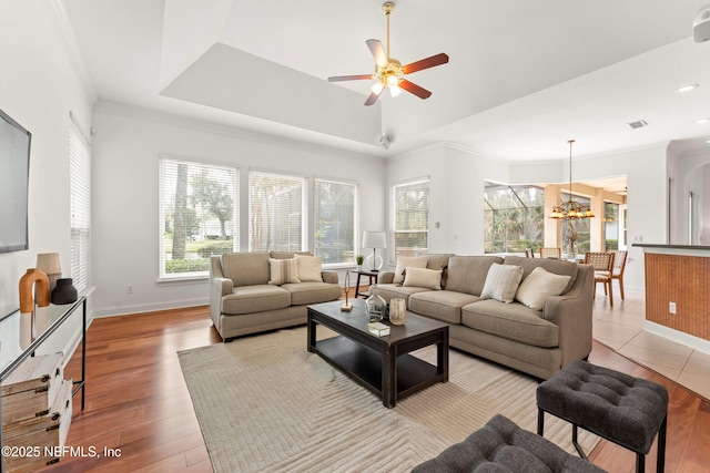 living room with light wood finished floors, baseboards, and ornamental molding