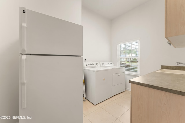 washroom with light tile patterned floors, a sink, and washer and dryer