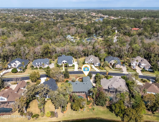 birds eye view of property featuring a forest view, a water view, and a residential view