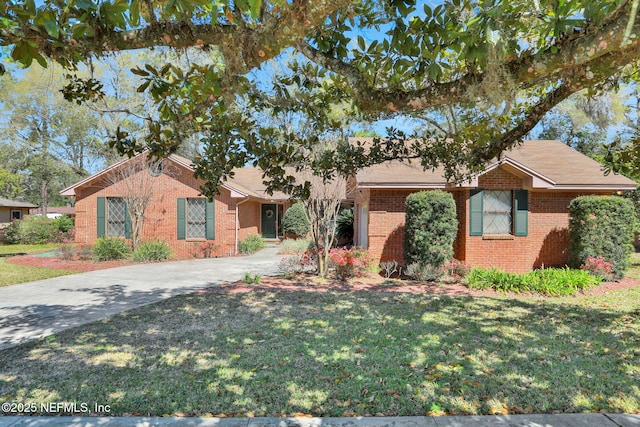 ranch-style house featuring a front yard, brick siding, and driveway