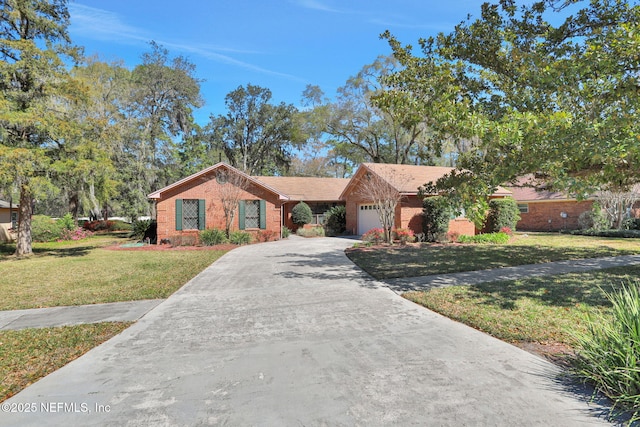 single story home with a garage, driveway, brick siding, and a front yard