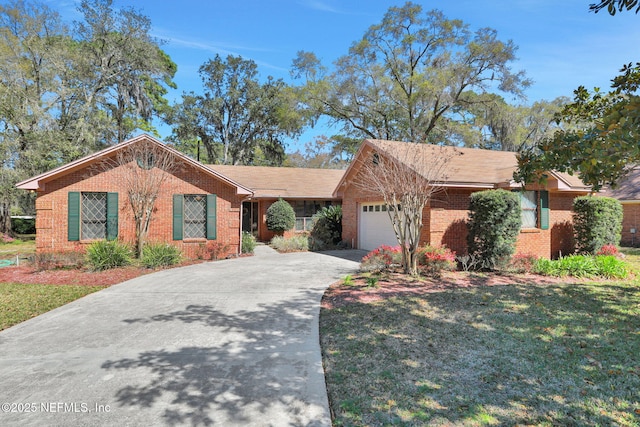 single story home featuring a garage, driveway, brick siding, and a front yard