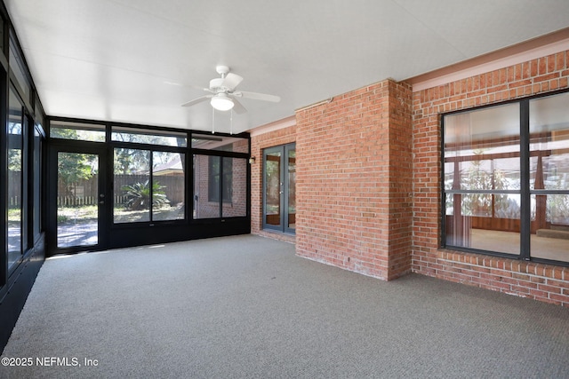 unfurnished sunroom with ceiling fan