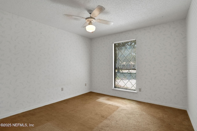 spare room featuring a textured ceiling, carpet floors, and a ceiling fan