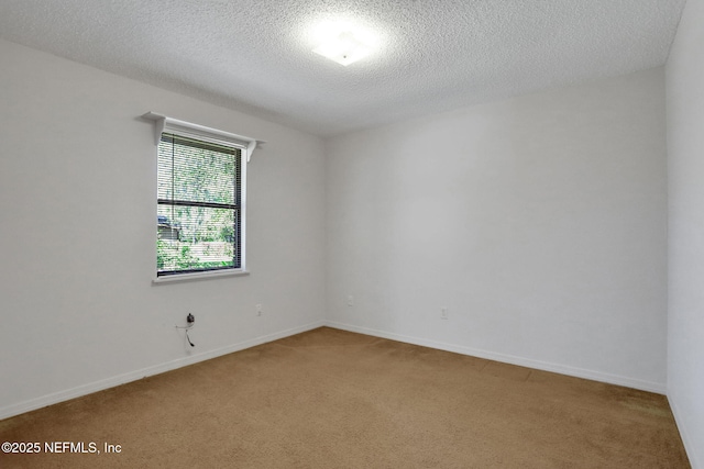 empty room featuring baseboards, a textured ceiling, and light colored carpet