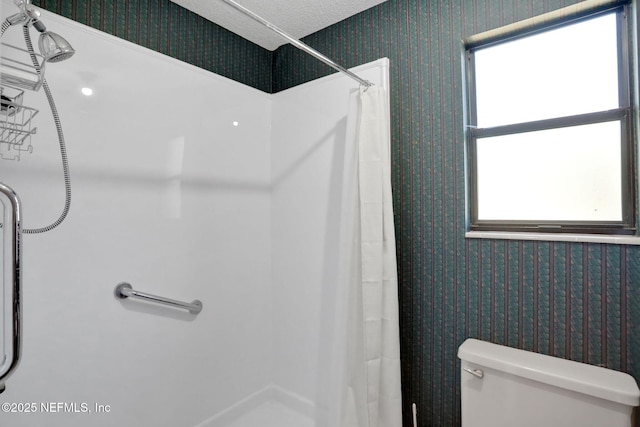 full bathroom featuring toilet, wallpapered walls, and curtained shower