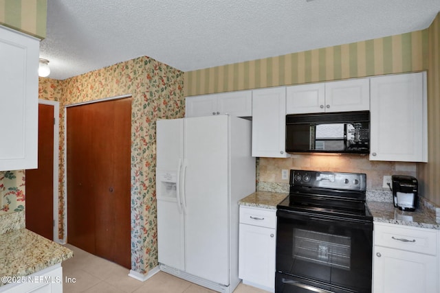 kitchen featuring a textured ceiling, black appliances, and wallpapered walls