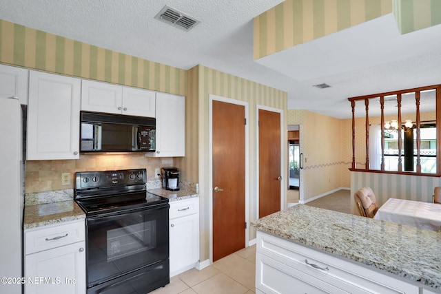 kitchen featuring a textured ceiling, black appliances, visible vents, and wallpapered walls