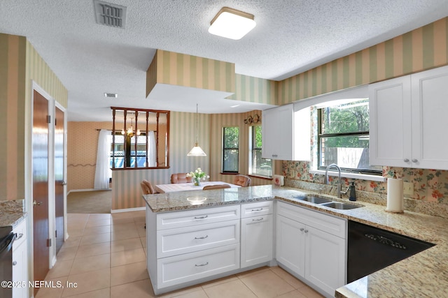 kitchen featuring a peninsula, wallpapered walls, visible vents, and a sink