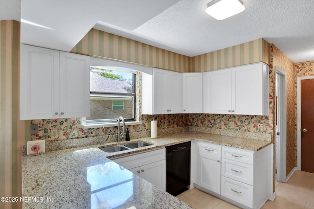 kitchen with wallpapered walls, black dishwasher, a textured ceiling, white cabinetry, and a sink