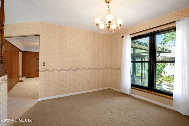 unfurnished room featuring wallpapered walls, baseboards, a notable chandelier, and light colored carpet