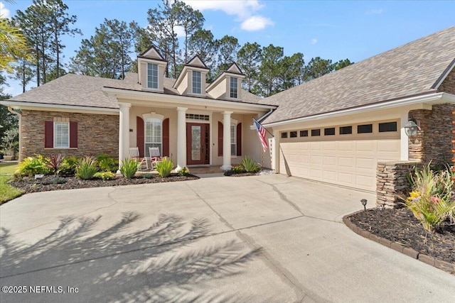 view of front of home featuring stucco siding, covered porch, an attached garage, stone siding, and driveway