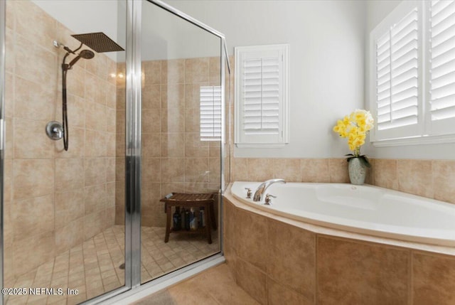 bathroom featuring a garden tub and a shower stall