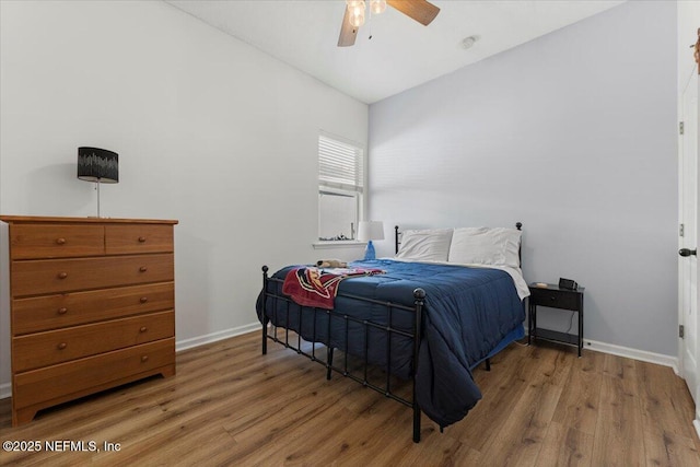 bedroom featuring lofted ceiling, ceiling fan, baseboards, and wood finished floors