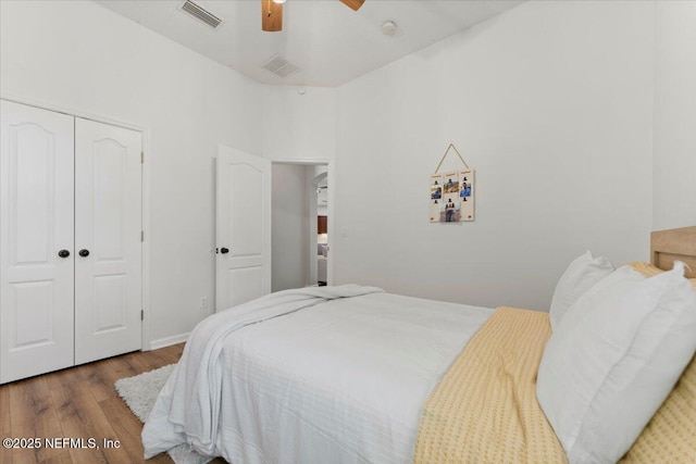 bedroom with a closet, visible vents, ceiling fan, and wood finished floors