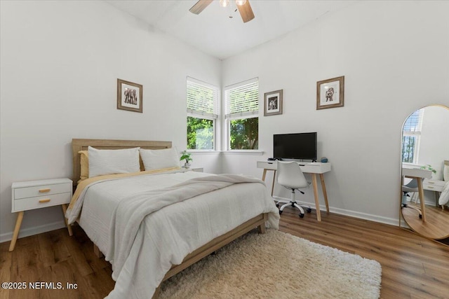 bedroom with ceiling fan, wood finished floors, and baseboards