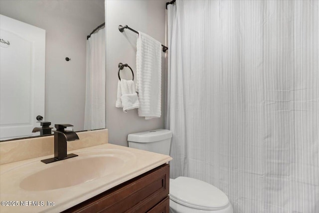 bathroom with curtained shower, vanity, and toilet