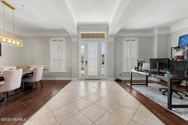 tiled foyer entrance with ornamental molding, visible vents, a textured ceiling, and baseboards