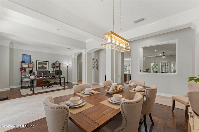 dining area featuring crown molding, arched walkways, visible vents, and decorative columns