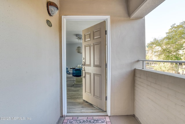 doorway to property featuring stucco siding and a balcony