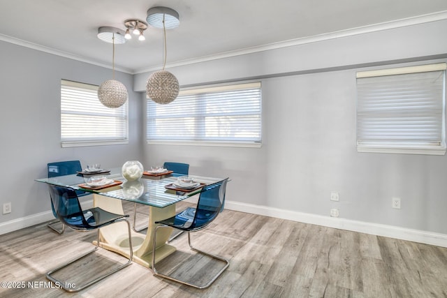 dining room featuring baseboards, wood finished floors, and crown molding