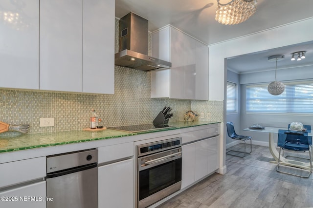 kitchen featuring modern cabinets, white cabinetry, wall chimney range hood, stainless steel oven, and black electric stovetop