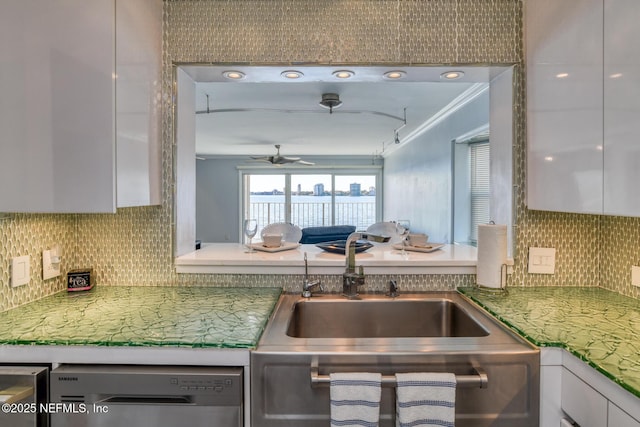 kitchen featuring stainless steel dishwasher, a ceiling fan, tasteful backsplash, and white cabinetry
