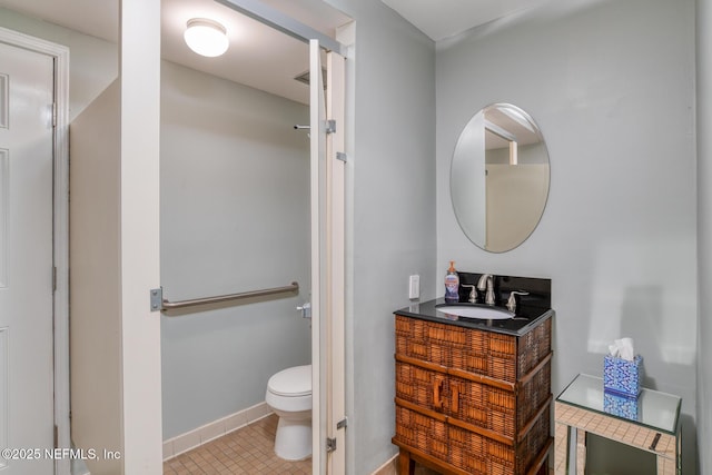 bathroom featuring tile patterned flooring, toilet, vanity, and baseboards