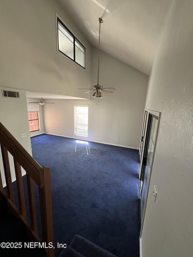 unfurnished room featuring a ceiling fan, carpet, a healthy amount of sunlight, and visible vents