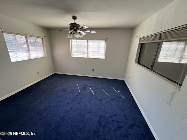 unfurnished room with ceiling fan, baseboards, and dark colored carpet