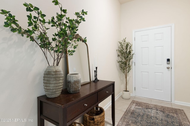 foyer entrance with light tile patterned floors and baseboards