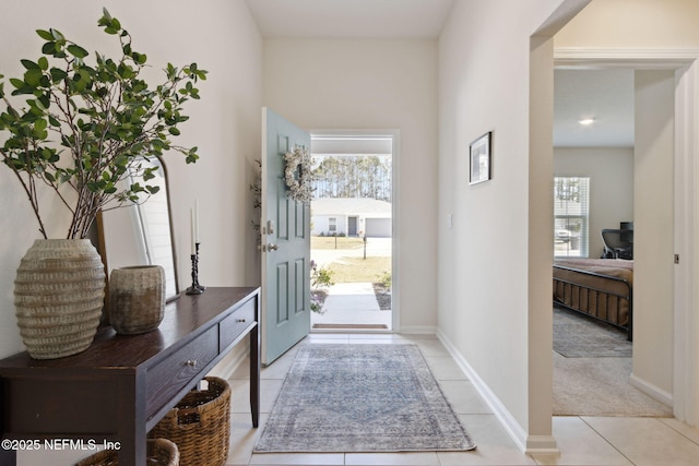 foyer entrance with light tile patterned floors and baseboards