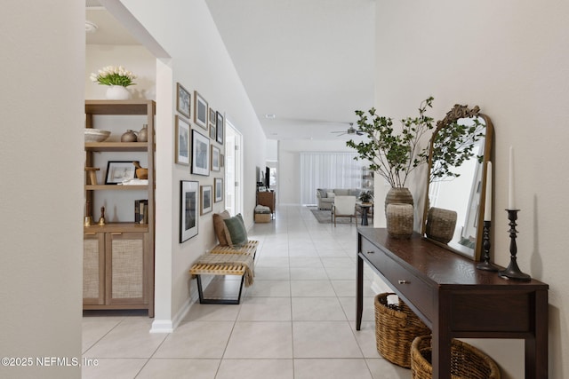 hall featuring light tile patterned flooring and baseboards