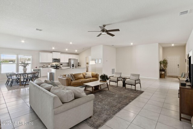 living room with light tile patterned floors, a textured ceiling, and visible vents