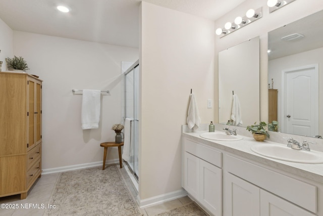 bathroom with a stall shower, tile patterned flooring, a sink, and double vanity