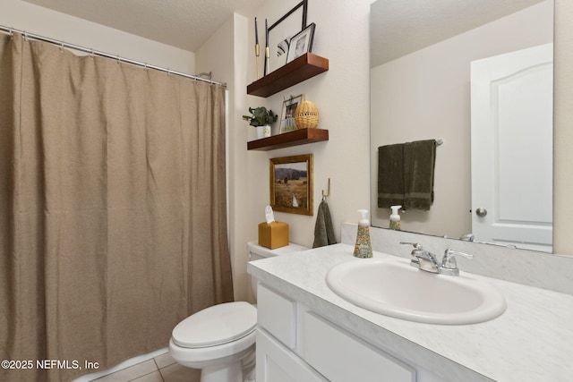 bathroom with a textured ceiling, vanity, toilet, and tile patterned floors