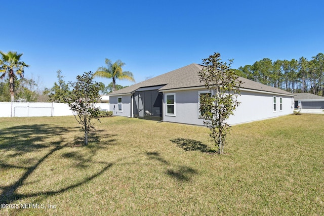 exterior space with stucco siding, fence, and a yard