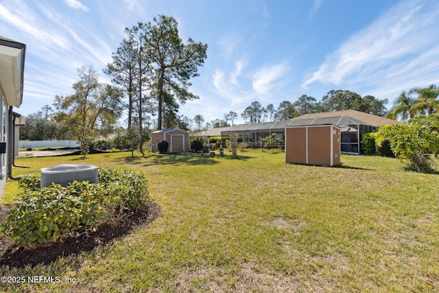 view of yard featuring a storage shed, central AC, and an outdoor structure