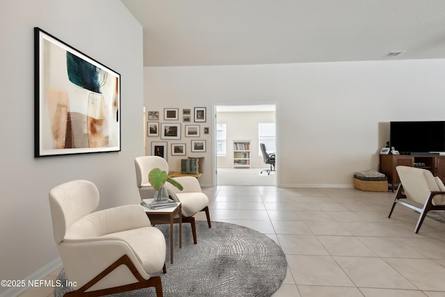 living area featuring baseboards, visible vents, and light tile patterned flooring