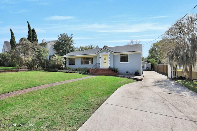 view of front of house with driveway, fence, and a front yard