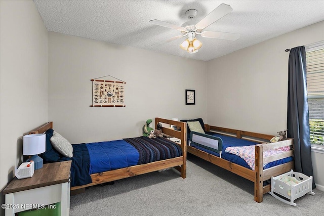 carpeted bedroom with ceiling fan and a textured ceiling