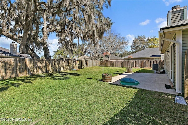 view of yard featuring a patio, a fenced backyard, and central air condition unit