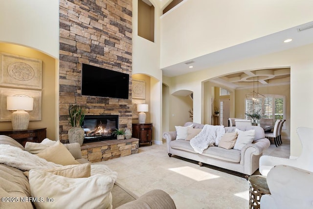 living room featuring a high ceiling, a fireplace, coffered ceiling, baseboards, and beamed ceiling